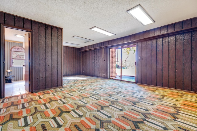 interior space featuring wooden walls and a textured ceiling