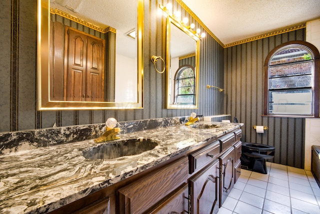 bathroom featuring tile patterned flooring, crown molding, a textured ceiling, toilet, and vanity