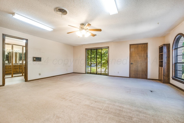 carpeted spare room with ceiling fan and a textured ceiling