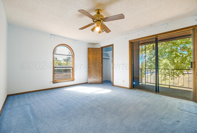 unfurnished bedroom featuring access to outside, ceiling fan, and a textured ceiling