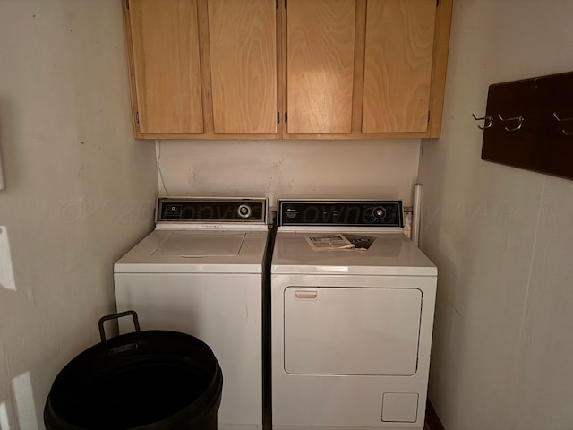 washroom with cabinets and washing machine and dryer