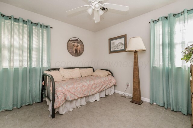 1709 Sunset Ave, Dumas, TX 79029 - bedroom with light tile patterned floors, ceiling fan, and baseboards