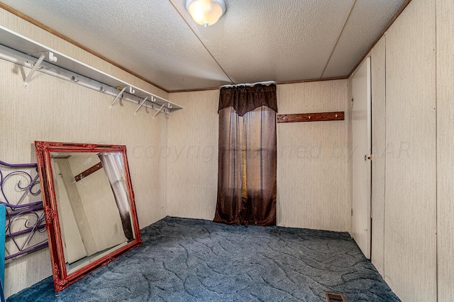 basement with a textured ceiling and dark carpet