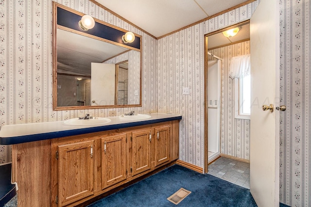 bathroom with tile patterned flooring, lofted ceiling, crown molding, and vanity