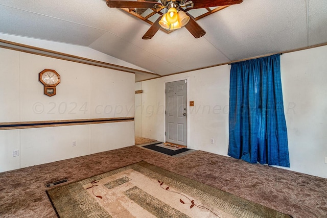 carpeted entrance foyer with ceiling fan, a textured ceiling, and lofted ceiling