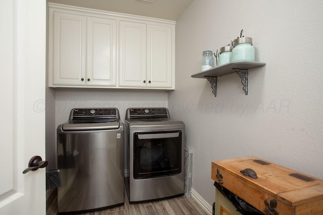 laundry area with cabinet space, light wood-style flooring, baseboards, and washer and dryer