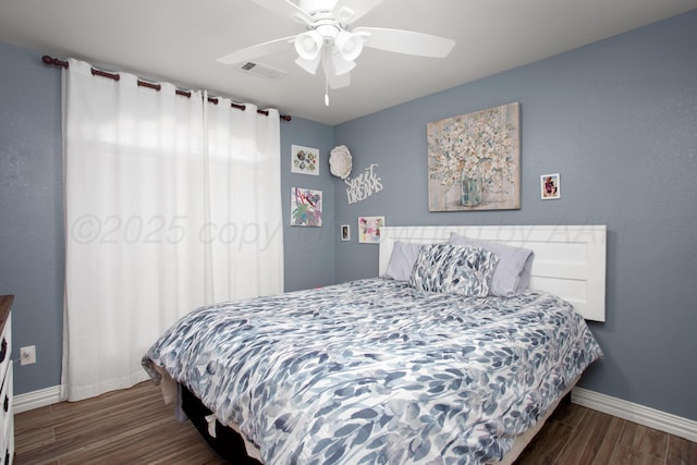 bedroom featuring baseboards, a ceiling fan, wood finished floors, and visible vents