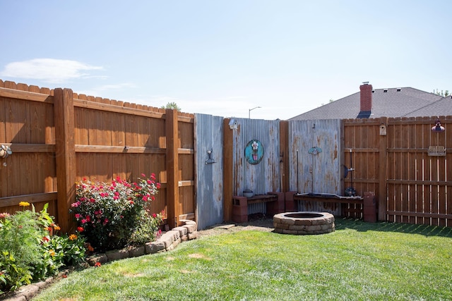 view of yard with a fire pit and a fenced backyard