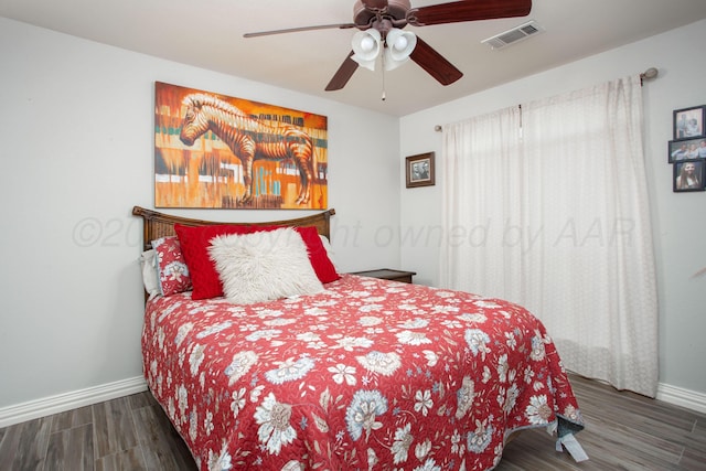 bedroom featuring wood finished floors, visible vents, baseboards, and ceiling fan