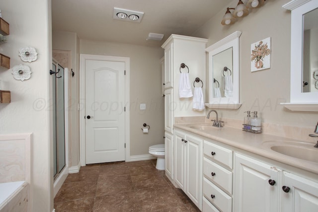 bathroom featuring a shower stall, toilet, a sink, and double vanity