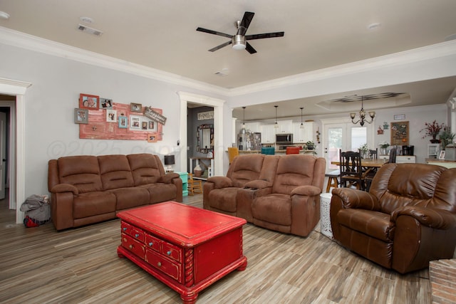 living room featuring ceiling fan, crown molding, visible vents, and light wood finished floors