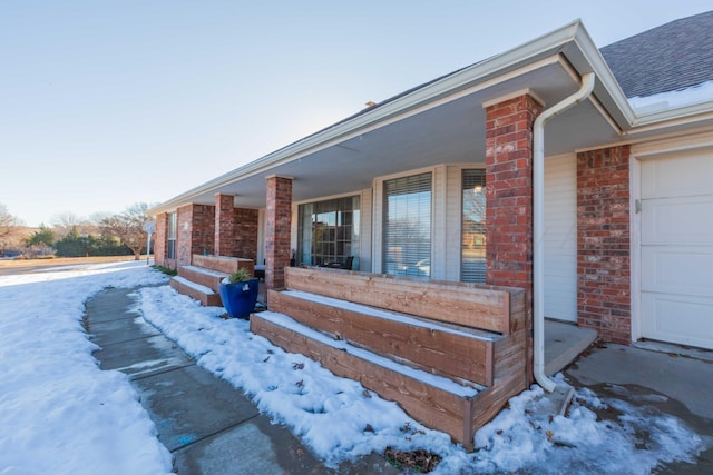 view of snow covered exterior with covered porch