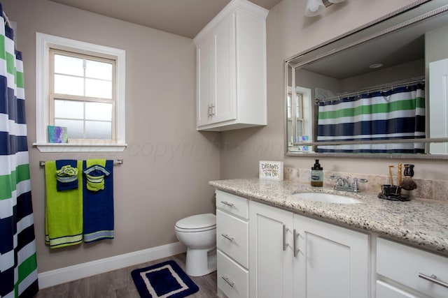 bathroom with toilet, wood-type flooring, and vanity