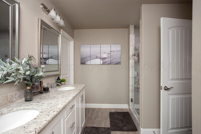 bathroom featuring an enclosed shower, vanity, and wood-type flooring