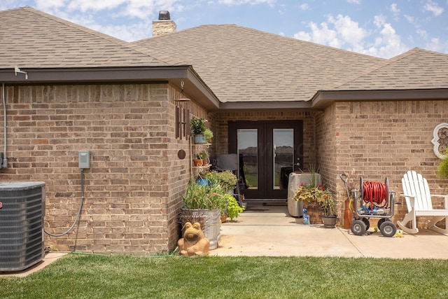 view of exterior entry featuring french doors, a patio area, and central AC unit