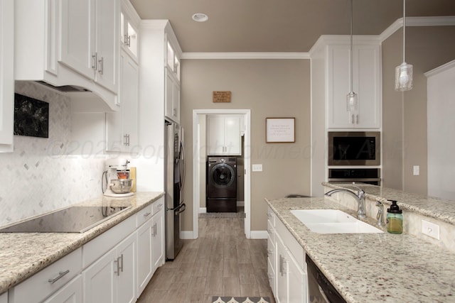 kitchen featuring sink, washer / clothes dryer, decorative light fixtures, white cabinets, and appliances with stainless steel finishes