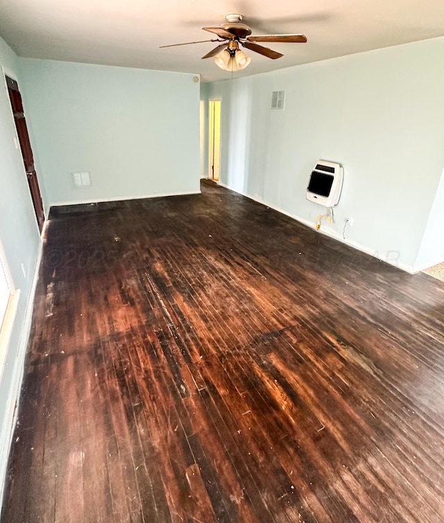 unfurnished living room with dark wood-type flooring, ceiling fan, and heating unit