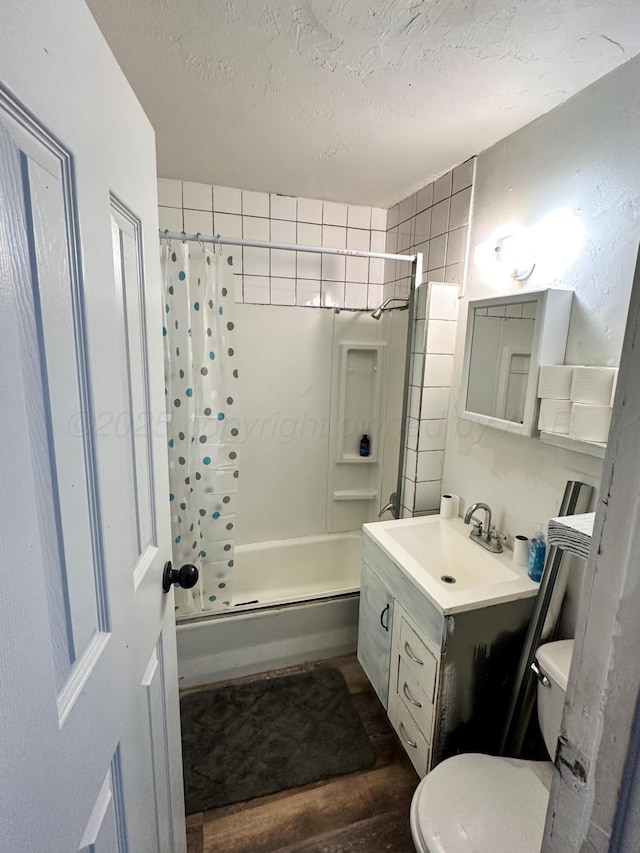 full bathroom with wood-type flooring, vanity, toilet, shower / bath combo, and a textured ceiling