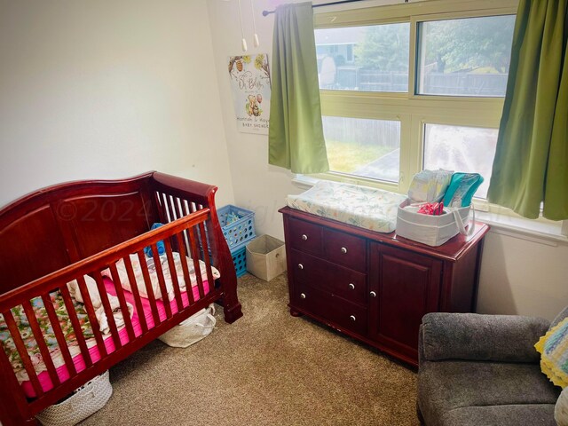 carpeted bedroom featuring a crib