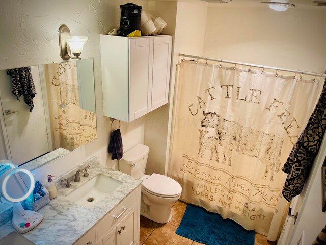 bathroom with vanity, tile patterned flooring, and toilet