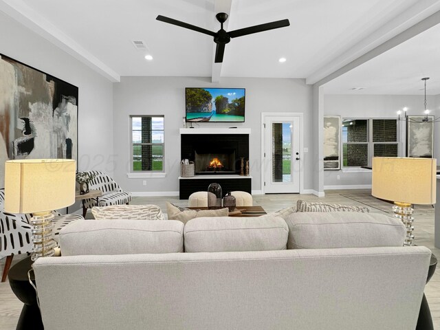 19150 Pecan Springs Rd, Amarillo, TX 79119 - living room with ceiling fan, beamed ceiling, a lit fireplace, baseboards, and a chandelier