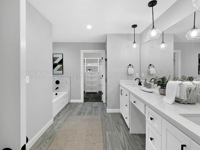 19150 Pecan Springs Rd, Amarillo, TX 79119 - full bathroom with double vanity, a garden tub, baseboards, wood finished floors, and recessed lighting