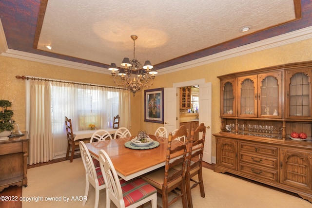 carpeted dining area with a textured ceiling, a raised ceiling, an inviting chandelier, and crown molding