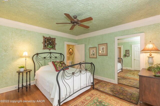 bedroom featuring a textured ceiling, wood-type flooring, ceiling fan, and crown molding