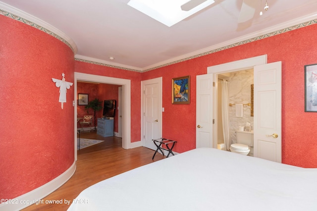 bedroom with ensuite bathroom, hardwood / wood-style floors, ceiling fan, and crown molding