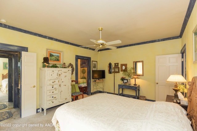 carpeted bedroom with ornamental molding and ceiling fan