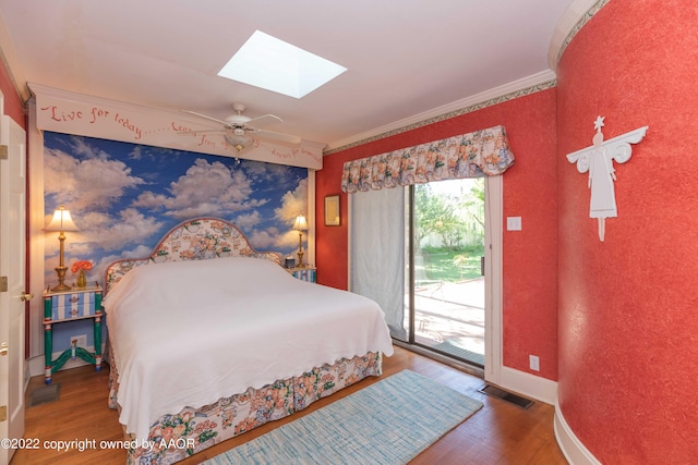 bedroom with access to exterior, hardwood / wood-style floors, ornamental molding, ceiling fan, and a skylight