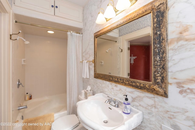 full bathroom featuring toilet, shower / bath combo, tile walls, and sink