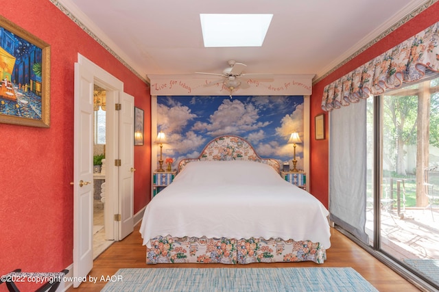 bedroom featuring access to exterior, ceiling fan, a skylight, hardwood / wood-style floors, and crown molding