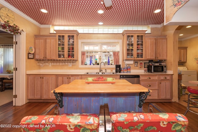 kitchen featuring appliances with stainless steel finishes, sink, dark hardwood / wood-style flooring, and ornamental molding