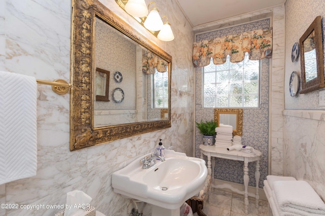 bathroom with tile walls, sink, and crown molding