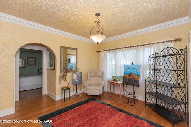 1607 S Harrison St, Amarillo, TX 79102 - living area featuring ornamental molding, wood finished floors, a textured ceiling, arched walkways, and a textured wall
