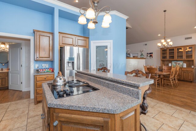 kitchen featuring black electric cooktop, stainless steel refrigerator with ice dispenser, decorative light fixtures, and light hardwood / wood-style flooring