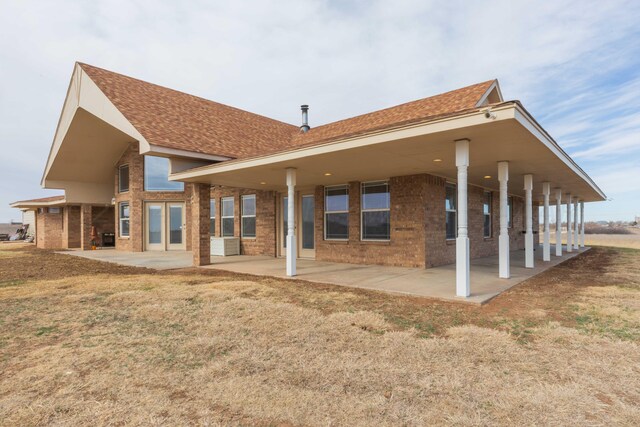 rear view of property featuring a lawn and a patio area