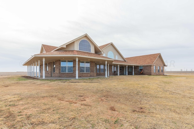 farmhouse-style home with a front yard and covered porch