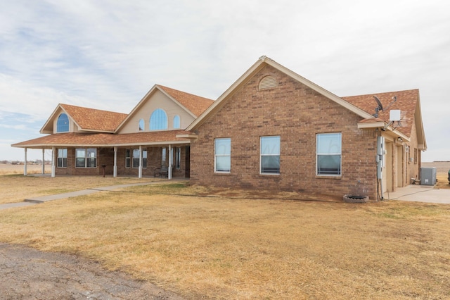 view of front of property with central air condition unit, a porch, and a front lawn