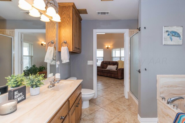 bathroom with tile patterned flooring, vanity, a healthy amount of sunlight, and a shower with door