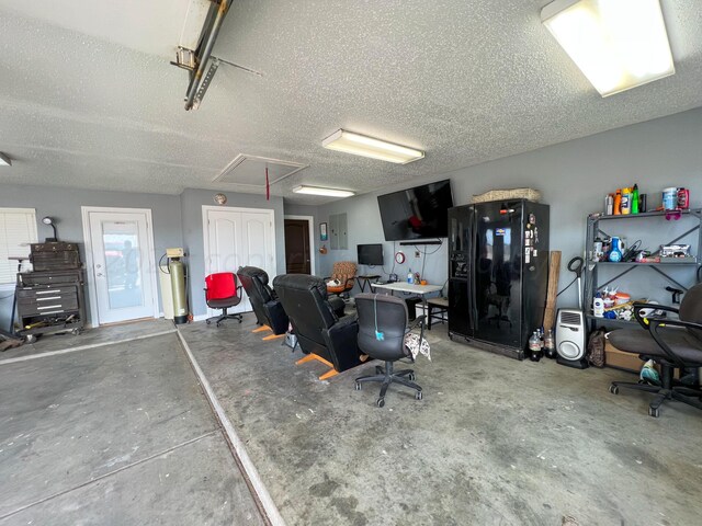 garage with electric panel and black fridge