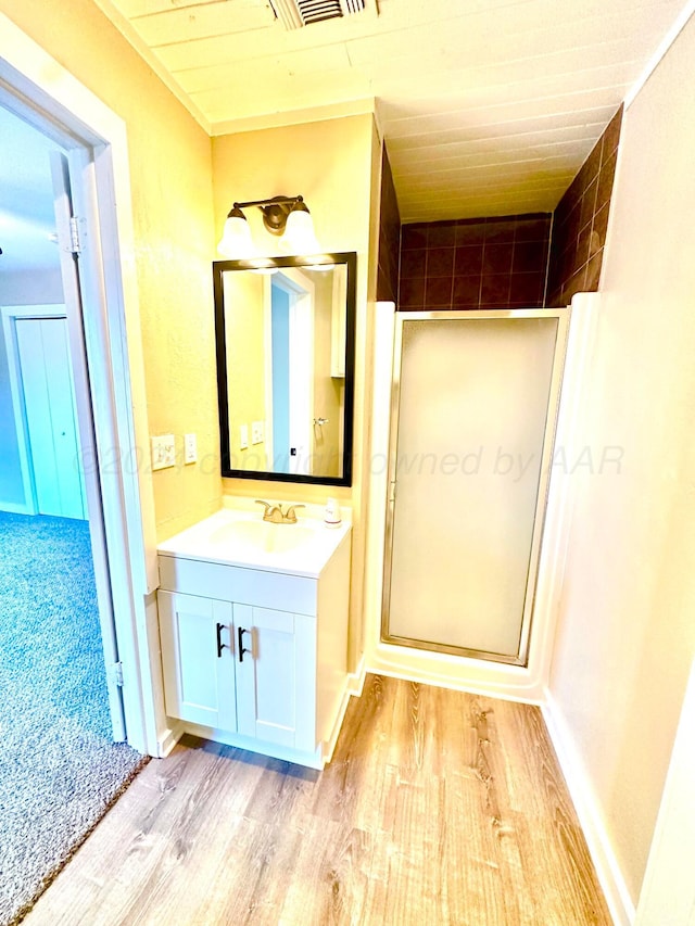 222 E 5th St, Higgins, TX 79046 - full bathroom with wood finished floors, a shower stall, and vanity