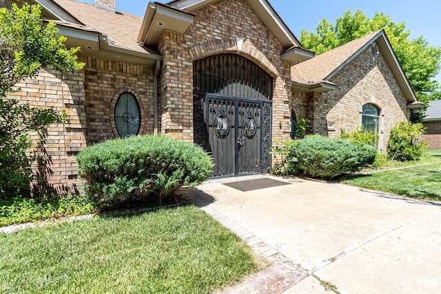7402 Park Ridge Dr, Amarillo, TX 79119 - property entrance with brick siding, roof with shingles, a gate, and a chimney