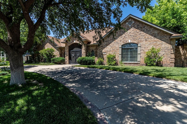 7402 Park Ridge Dr, Amarillo, TX 79119 - view of front of house with brick siding, curved driveway, and a front yard