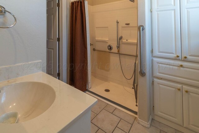 7402 Park Ridge Dr, Amarillo, TX 79119 - full bathroom with a shower stall, vanity, and tile patterned floors