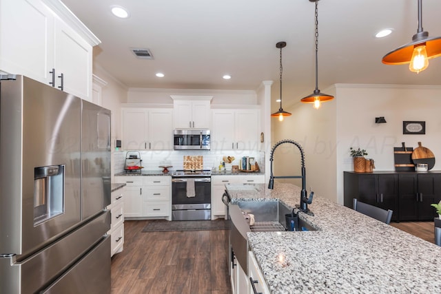 25 Nicci Ln, Canyon, TX 79015 - kitchen with appliances with stainless steel finishes, white cabinetry, decorative backsplash, dark wood finished floors, and crown molding