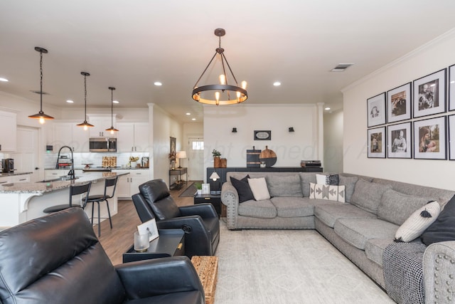25 Nicci Ln, Canyon, TX 79015 - living room featuring ornamental molding, a chandelier, recessed lighting, and light wood-style flooring