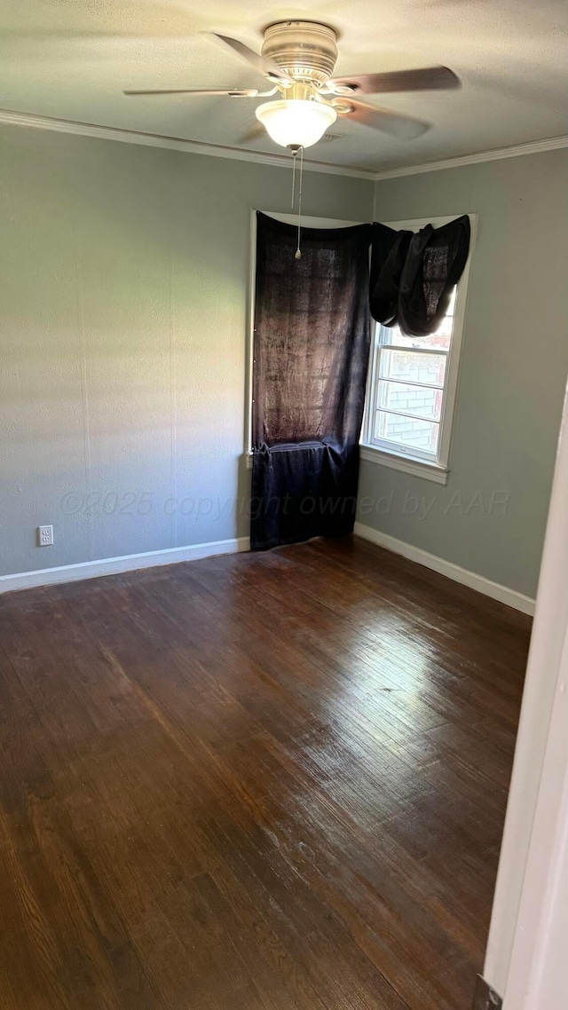 spare room featuring wood finished floors, a ceiling fan, ornamental molding, and baseboards