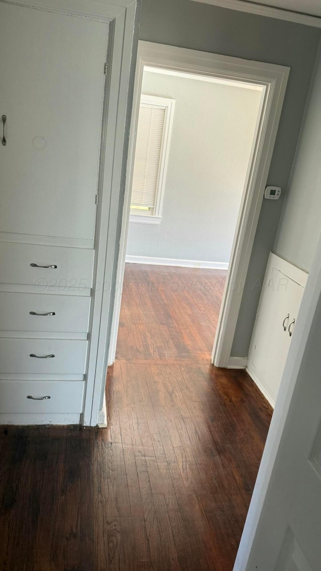 hall featuring baseboards and dark wood finished floors